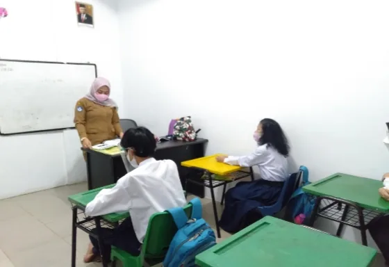Guru mengajar di depan kelas