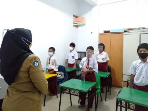 Siswa berdiri di samping meja saat pembelajaran dimulai