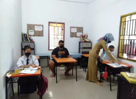 Guru membimbing siswa saat mengerjakan tugas